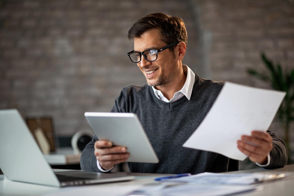 happy businessman using touchpad laptop while working business reports office