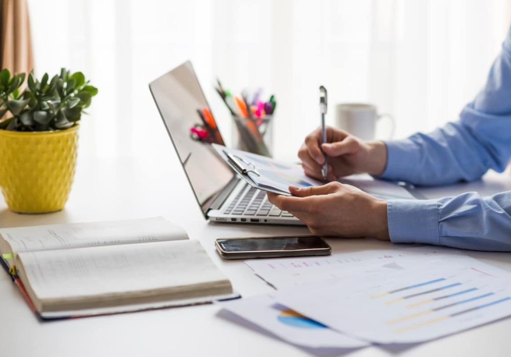 crop-man-writing-documents-office